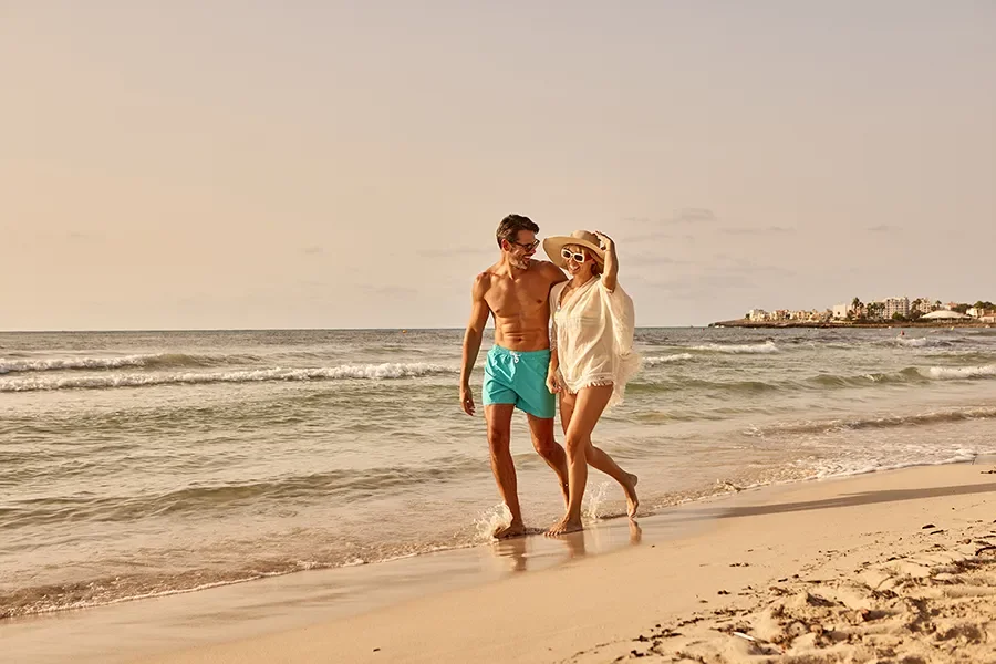 Pareja paseando por la orilla de la playa