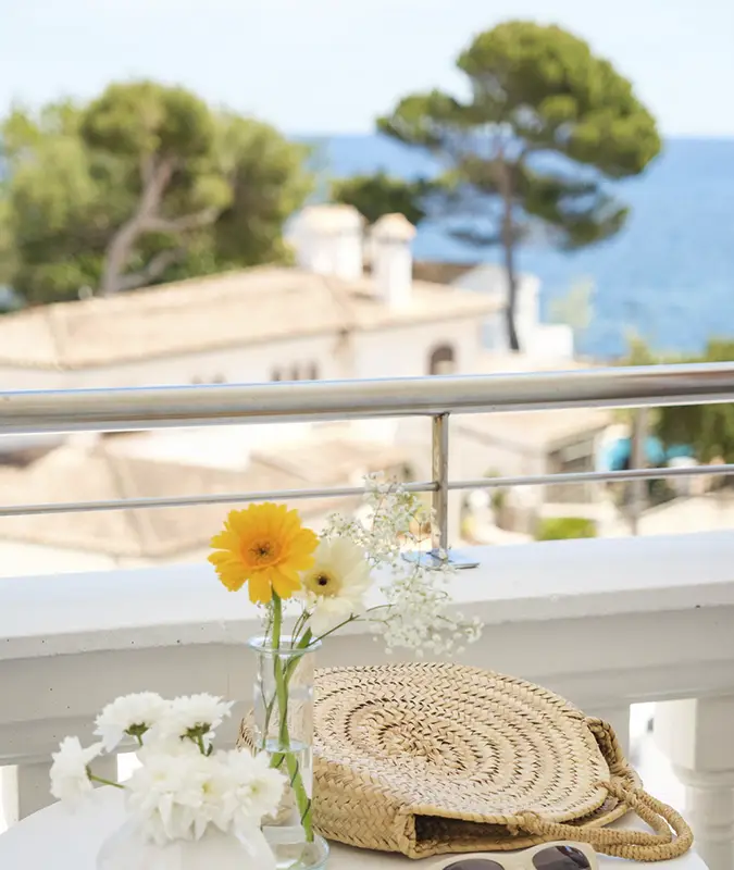 Detalle de una mesa en un balcón con vistas al mar Welikehotel
