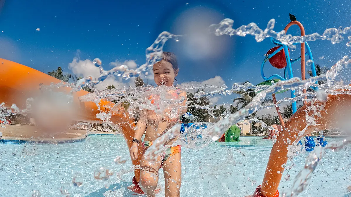 Niña jugando en una piscina de parque acuático