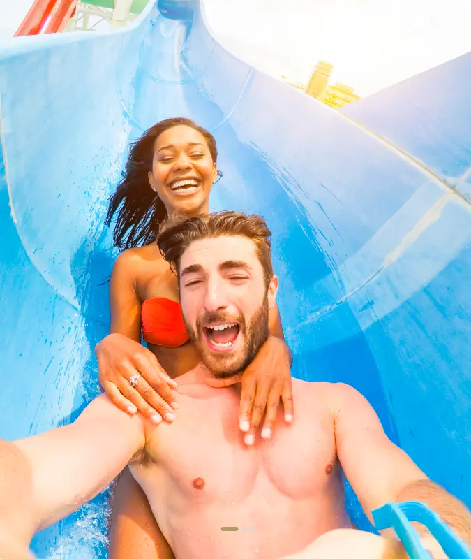 Pareja deslizándose por un tobogán acuático