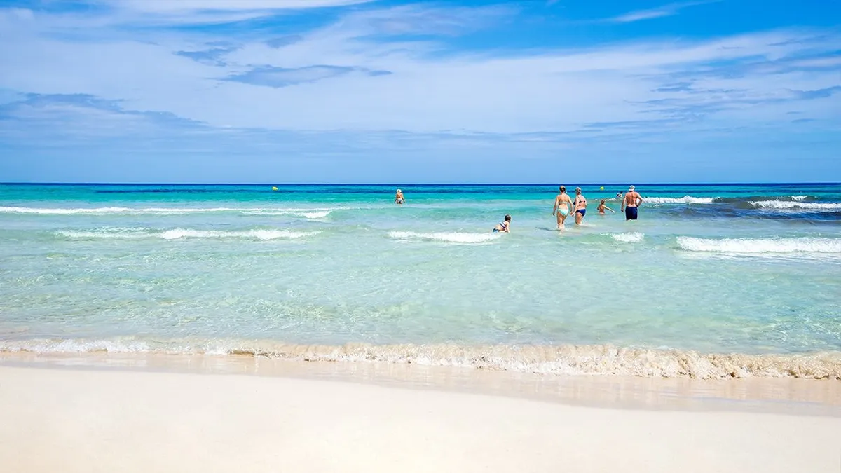 Gente bañandose en la playa de Sa Coma Welikehotel