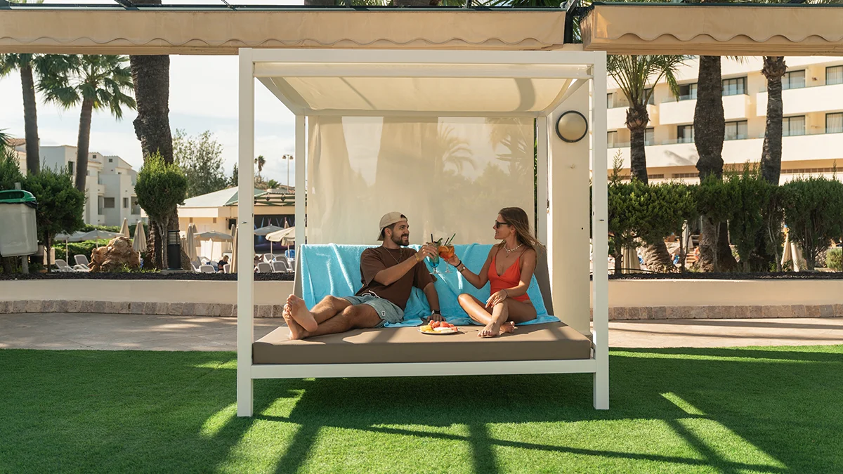 Pareja en cama balinesa de la Piscina de Welikehotel Marfil Playa