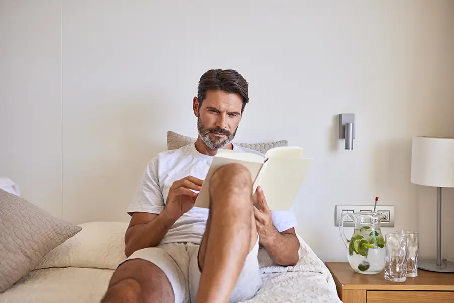 Camas confortables Mujer sentada en la cama de la habitación Welike Hotel Marfil Playa