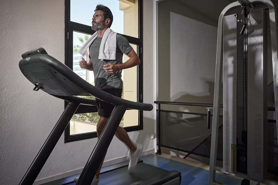 Hombre en la cinta de correr del gimnasio hotel Welikehotel Marfil Playa