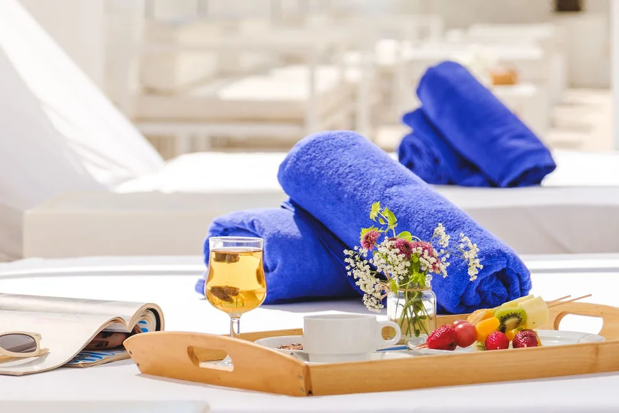 Comida en bandeja sobre cama balinesa hotel Welikehotel Triton Beach